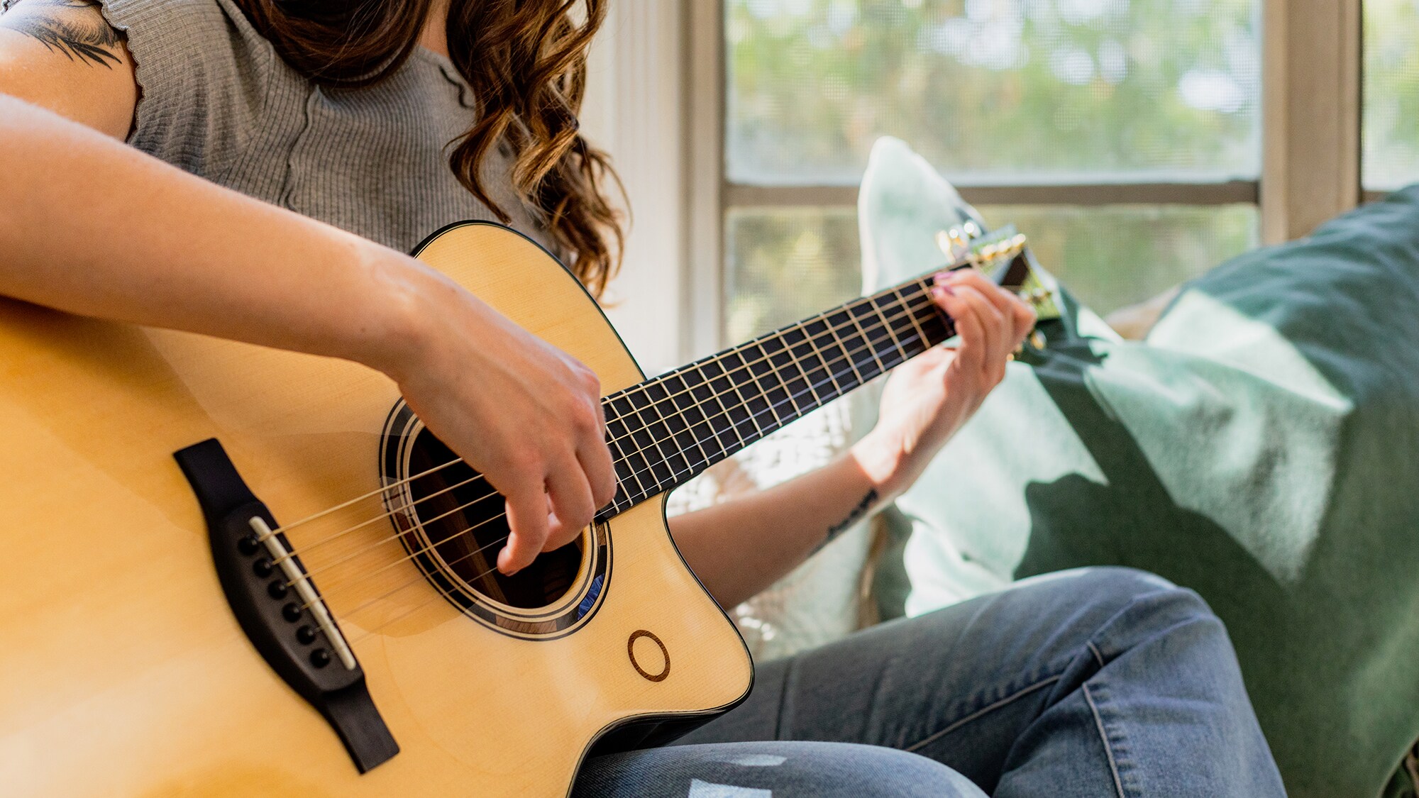 Close-up of a person playing the TAS3 C acoustic guitar.
