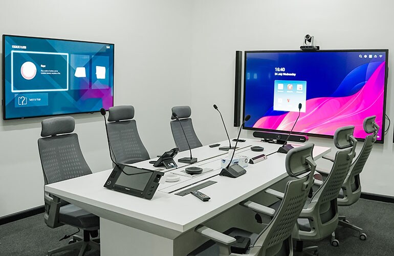 Dubai training facility meeting room with conference table, video displays, and presentation equipment.