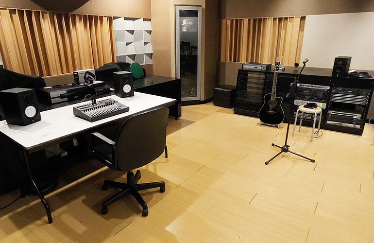 Jakarta training facility room with tables, seating, and audio training equipment.