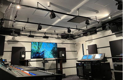 Yokohama training facility with a large display, digital mixing consoles, loudspeakers, and audio equipment.
