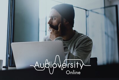 A man sitting in front of a PC and looking outside. Audioversity Online logo shown at the bottom of the image.